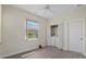 Bright room with a laundry closet with stacked machines, ceiling fan, and wood-look flooring at 6766 Greenview Ln, Englewood, FL 34224