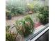 View of the backyard from the window featuring potted plants, green grass, and a fenced perimeter at 7183 Wood Creek Dr # 9, Sarasota, FL 34231