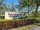 Entrance sign to Woodside Terrace community with tropical landscaping at 7183 Wood Creek Dr # 9, Sarasota, FL 34231