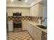 Traditional kitchen with white cabinets, stainless steel appliances, and colorful backsplash at 7183 Wood Creek Dr # 9, Sarasota, FL 34231
