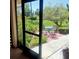 View of a peaceful outdoor patio with a table and chairs set amidst lush greenery at 7183 Wood Creek Dr # 9, Sarasota, FL 34231