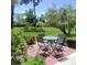 Outdoor patio features a table with four chairs, surrounded by lush greenery and landscaping at 7183 Wood Creek Dr # 9, Sarasota, FL 34231