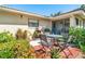 Outdoor patio features a table with four chairs, surrounded by lush landscaping and a building exterior at 7183 Wood Creek Dr # 9, Sarasota, FL 34231