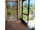 Screened porch featuring an entry door and a lattice-covered wall, leading to a patio at 7183 Wood Creek Dr # 9, Sarasota, FL 34231