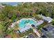 Aerial view of community pool featuring lounge chairs, palm trees, and a clubhouse at 7351 Meeting St, Bradenton, FL 34201