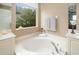 Luxurious bathroom featuring a large soaking tub, elegant fixtures, and bright natural light from the window at 7351 Meeting St, Bradenton, FL 34201