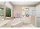 Bright bathroom featuring double sinks, soaking tub, walk-in shower, and natural light at 7351 Meeting St, Bradenton, FL 34201