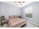 Simple bedroom with wood floors, light blue walls, ceiling fan, and natural light at 7351 Meeting St, Bradenton, FL 34201