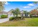 Beautifully landscaped front yard with palm trees, lush greenery, and a well-maintained lawn at 7351 Meeting St, Bradenton, FL 34201
