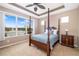 Spacious main bedroom featuring a four poster bed and a large window offering serene lake views at 7351 Meeting St, Bradenton, FL 34201