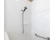 Clean and modern shower with white tiles, an adjustable shower head, and safety grab bar at 7351 Meeting St, Bradenton, FL 34201