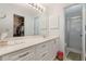 Bright bathroom featuring double sinks, a walk-in shower, and walk-in closet at 756 Avenida Estancia # 162, Venice, FL 34292