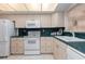 Functional kitchen featuring classic white appliances, tile flooring, and a bright, efficient layout at 756 Avenida Estancia # 162, Venice, FL 34292