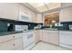 Bright kitchen featuring white appliances, ample counter space, and overhead lighting at 756 Avenida Estancia # 162, Venice, FL 34292
