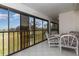 Relaxing screened patio with tile flooring and seating area overlooking lush green space at 756 Avenida Estancia # 162, Venice, FL 34292
