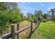 A view of the backyard showing the grass and wooded area in the landscape at 7677 Saddle Creek Trl, Sarasota, FL 34241