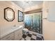 Cozy bathroom with single sink, tiled floor, and shower with fish curtain at 7677 Saddle Creek Trl, Sarasota, FL 34241