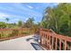 Wood-railed deck showcasing the scenic landscape and blue skies at 7677 Saddle Creek Trl, Sarasota, FL 34241