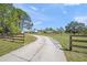 Long winding driveway leading to a beautiful home on a sunny day, showcasing the property's spacious lot at 7677 Saddle Creek Trl, Sarasota, FL 34241