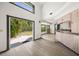 Sun-filled living room transitions into kitchen area with sliding glass doors to the outdoors at 7677 Saddle Creek Trl, Sarasota, FL 34241
