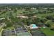 Aerial view of a golf course community with tennis courts, clubhouse, pool, lakes, and lush greenery at 7767 Pine Trace Dr, Sarasota, FL 34243