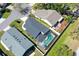 This aerial view shows the screened-in pool and backyard of a well-maintained house surrounded by lush greenery at 7767 Pine Trace Dr, Sarasota, FL 34243