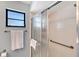 Bright bathroom featuring a glass shower door, white tile and a convenient towel rack at 7767 Pine Trace Dr, Sarasota, FL 34243