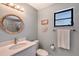 Bathroom with gray walls, a round mirror, and a shower with glass door at 7767 Pine Trace Dr, Sarasota, FL 34243