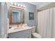 Bright bathroom with a white vanity, framed mirror and shower curtain at 7767 Pine Trace Dr, Sarasota, FL 34243