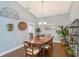 Warm dining area features hardwood floors, chandelier, wooden table and seating, and decorative accents creating inviting atmosphere at 7767 Pine Trace Dr, Sarasota, FL 34243