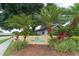 Welcoming community entrance sign with lush landscaping and colorful plants at Pine Trace at 7767 Pine Trace Dr, Sarasota, FL 34243