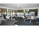 A well-equipped fitness center with various machines, weights, and a view of the pool area at 7767 Pine Trace Dr, Sarasota, FL 34243
