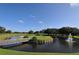 Beautiful golf course landscape featuring a bridge, water fountain and well manicured greenery under a clear blue sky at 7767 Pine Trace Dr, Sarasota, FL 34243