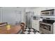 Well-lit kitchen features stainless steel appliances, white cabinets, checkered tile floors, and breakfast nook with dining table at 7767 Pine Trace Dr, Sarasota, FL 34243