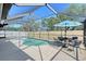 Sparkling pool inside of a screened in lanai, and cozy furniture for relaxing and entertaining in style at 7767 Pine Trace Dr, Sarasota, FL 34243