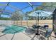 Screened-in pool area with a patio table and chairs ready for outdoor dining at 7767 Pine Trace Dr, Sarasota, FL 34243