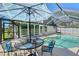 The photo presents an inviting in-ground pool, comfortable seating, and a patio with an umbrella at 7767 Pine Trace Dr, Sarasota, FL 34243