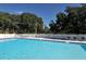 A sparkling community swimming pool featuring clear blue water and surrounding lounge chairs and fence at 7767 Pine Trace Dr, Sarasota, FL 34243