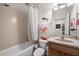 Bathroom featuring tile walls, white shower curtain, wooden vanity and a decorative fish ornament at 7959 Limestone Ln # 14-104, Sarasota, FL 34233