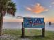 Photo of Siesta Key beach sign set against a beautiful sunset backdrop with a palm tree at 7959 Limestone Ln # 14-104, Sarasota, FL 34233