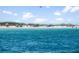 A sunny beach view with clear turquoise waters, white sand, and people enjoying the weather at 7959 Limestone Ln # 14-104, Sarasota, FL 34233