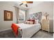 Bright bedroom featuring a ceiling fan, grey carpet, a large patterned headboard, and decorative pillows at 7959 Limestone Ln # 14-104, Sarasota, FL 34233