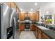 Modern kitchen featuring stainless steel appliances, light wood cabinets, and black countertops at 7959 Limestone Ln # 14-104, Sarasota, FL 34233