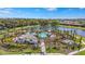 Scenic aerial view of a lush community featuring a pool, lake, and mature landscaping for a serene living environment at 8108 Wild Blue Ter, Sarasota, FL 34241