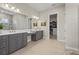 Bathroom with dual vanity, neutral tile, and access to a walk-in closet at 8108 Wild Blue Ter, Sarasota, FL 34241