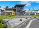 Grand clubhouse entrance featuring modern architecture, glass windows, and manicured landscaping at 8108 Wild Blue Ter, Sarasota, FL 34241