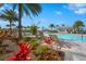 Inviting community pool with sun shelves, lounge chairs, shaded cabana, and tropical landscaping on a beautiful sunny day at 8108 Wild Blue Ter, Sarasota, FL 34241