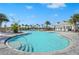 Inviting community pool with sun shelves, lounge chairs, shaded cabanas, and swaying palm trees on a beautiful sunny day at 8108 Wild Blue Ter, Sarasota, FL 34241