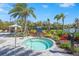 Community spa area featuring a hot tub, lounge chairs, shaded cabana, and tropical landscaping on a sunny day at 8108 Wild Blue Ter, Sarasota, FL 34241