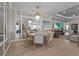 Dining room with a round table, seating for six, a modern chandelier, and mirrored wall accents and natural light at 8108 Wild Blue Ter, Sarasota, FL 34241